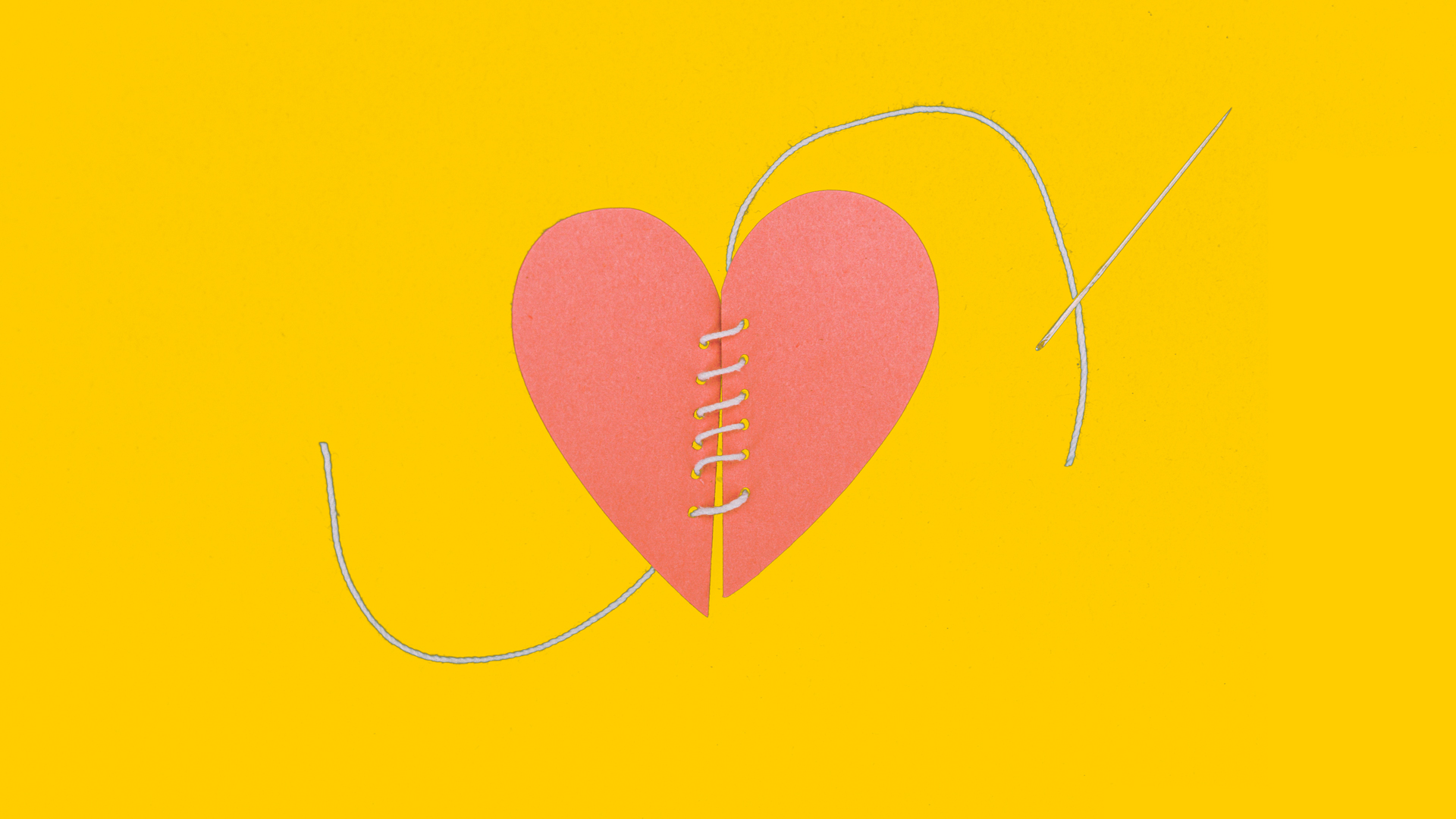 Two halves of a paper heart that are sewn together with a needle and thread