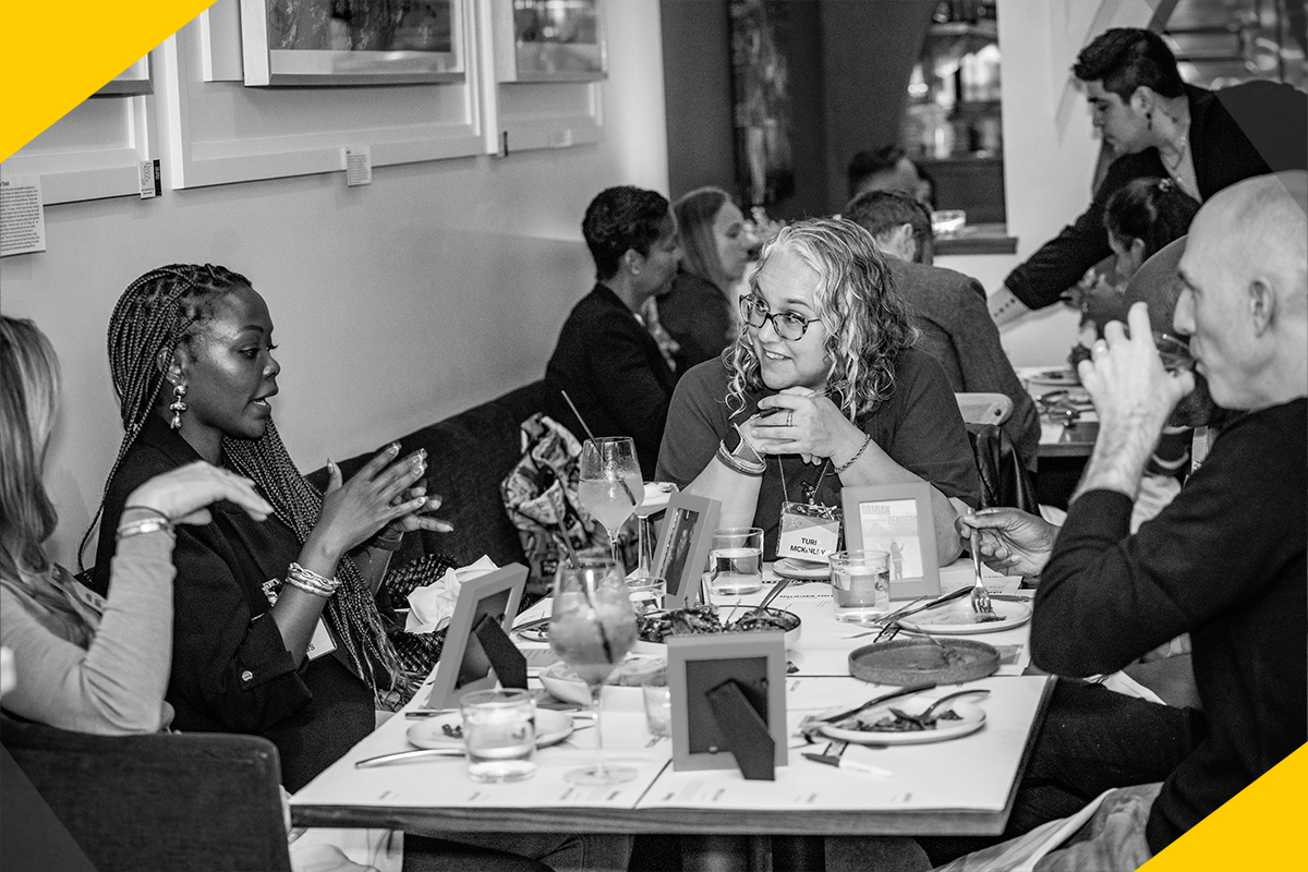 in_2024.09_img02 Guests talking while sitting around a table at Industry Night